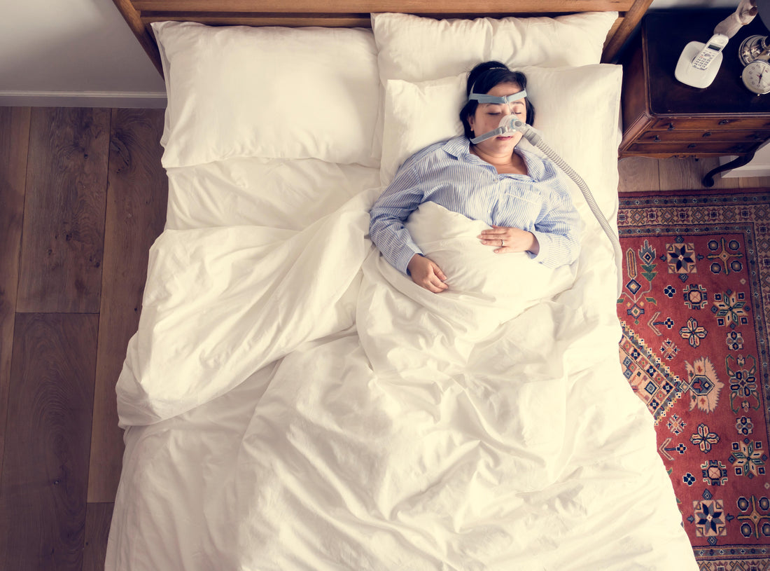 A woman sleeping with a CPAP device