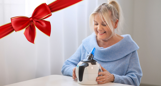 A woman sitting at a table with the WellO2 device